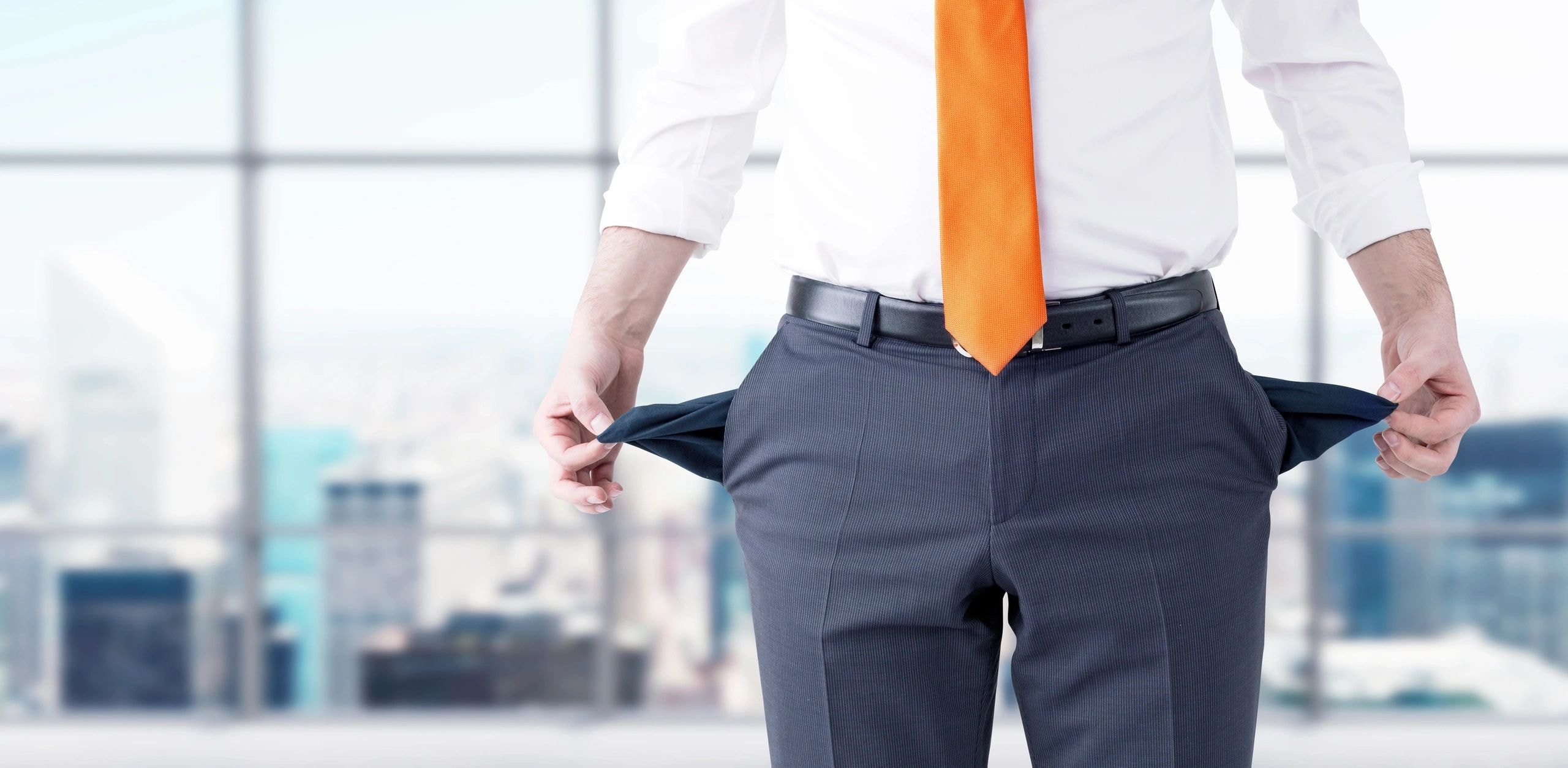 Businessman turning out empty pockets representing financial hardship and the need for bankruptcy solutions